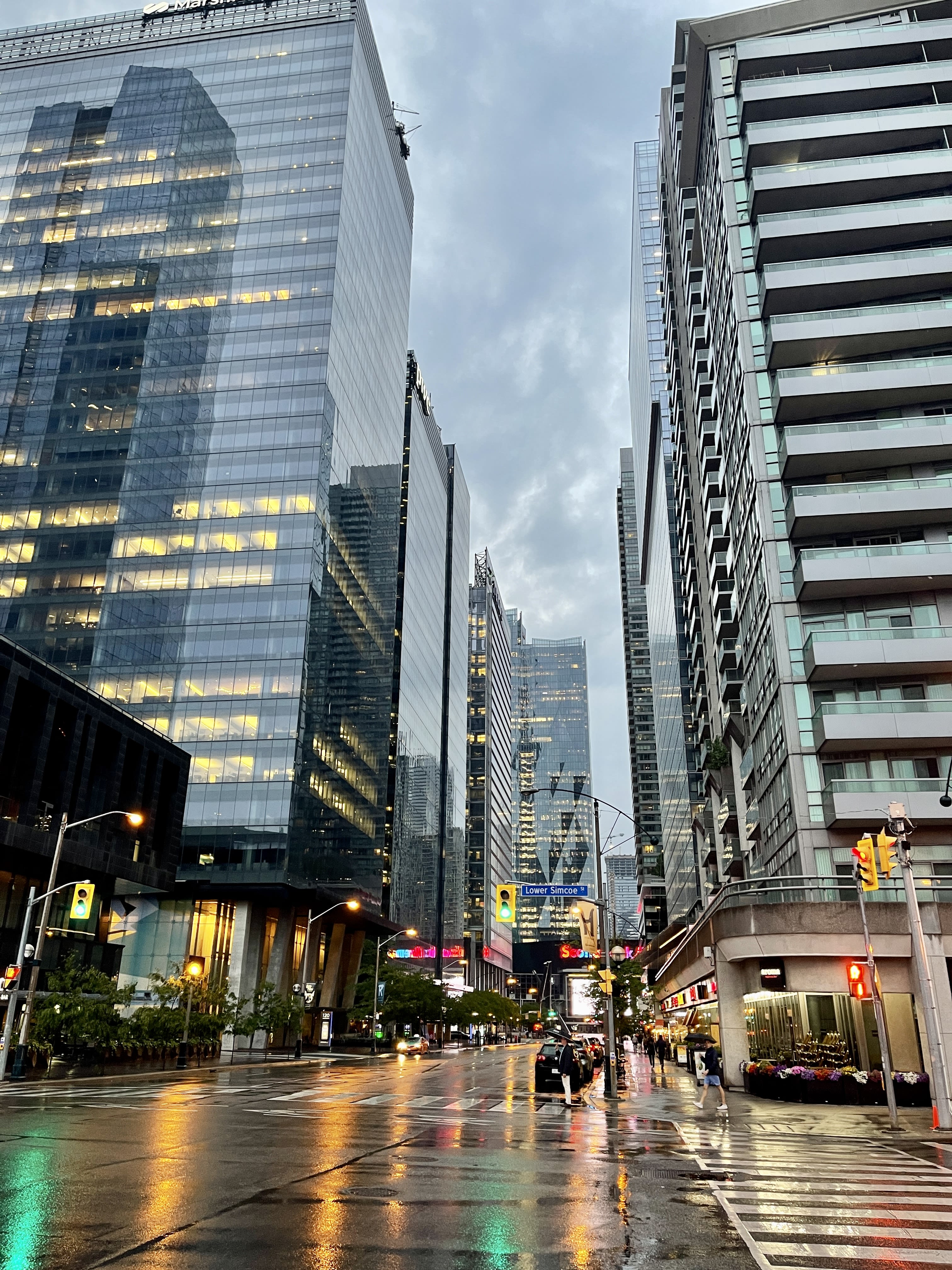 Shot of the city looking down a street after the rain with tall buildings on either side of the street.